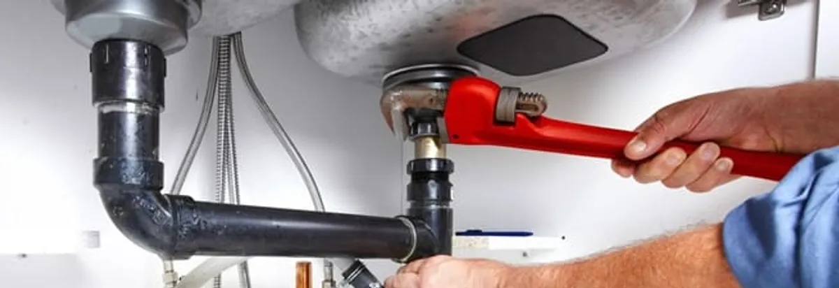 Garbage disposal repair technician tightening the sink drain and disposal connection in Baltimore, MD
