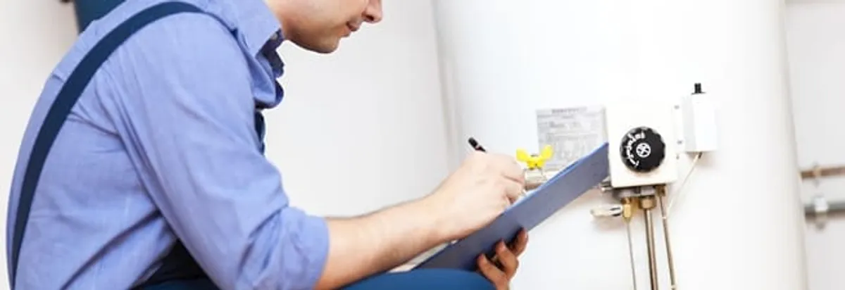 Water heater repair technician inspecting the unit and recording service notes in Baltimore, MD